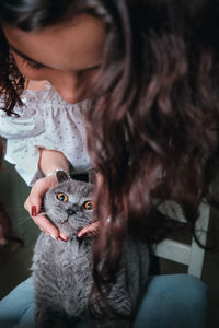 Close-up of young woman with cat at home