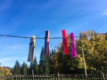 Low angle view of clothes hanging on clothesline against blue sky