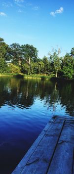 Reflection of trees in lake against blue sky