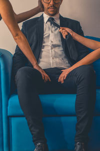 Low section of man sitting on sofa