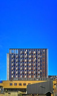 Low angle view of modern building against blue sky