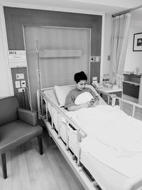 Young woman sitting on bed at home