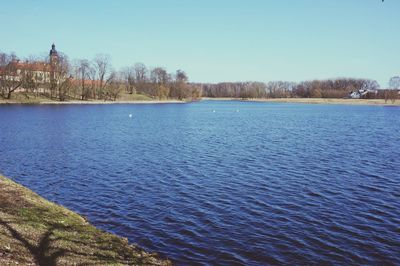 Scenic view of lake against clear blue sky