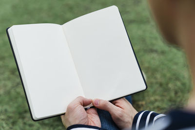 Midsection of man holding book