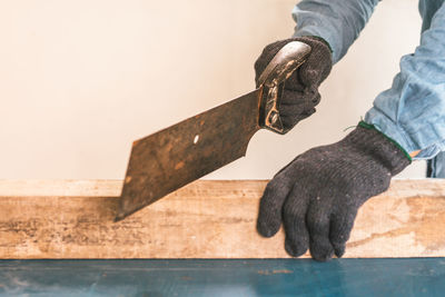 Cropped hands of carpenter cutting wood in workshop