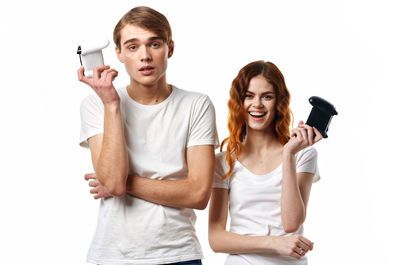 Portrait of young couple standing against white background