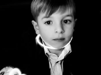 Portrait of cute boy against black background