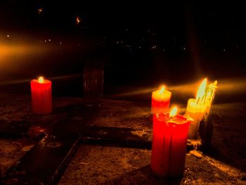 Lit candle in dark room