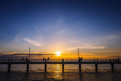 Bridge over river at sunset