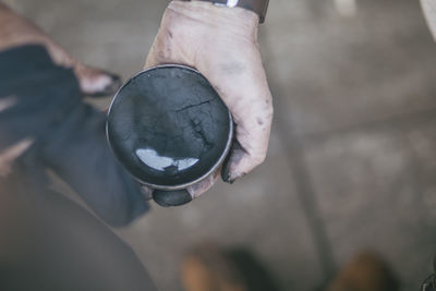 Cropped hand holding shoe polish