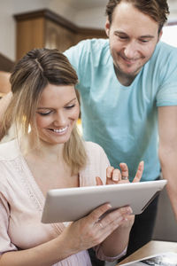 Smiling couple using digital tablet in kitchen