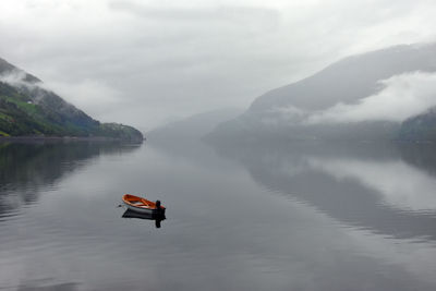 Scenic view of boat on lake against sky