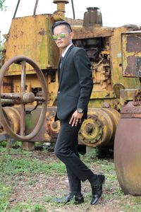 Full length portrait of young man standing against sky