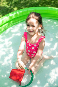 High angle view portrait of cute girl in baby pool