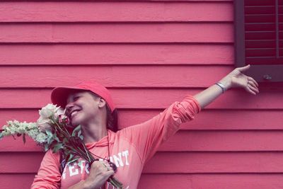 Low angle view of young woman with bouquet