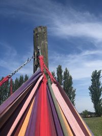 Low angle view of rope tied to pole against sky