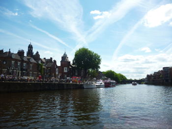 Scenic view of river by city against sky