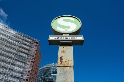 Low angle view of text on building against clear blue sky