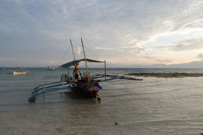 Fishing boat on sea against sky