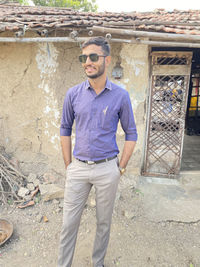 Portrait of young man wearing sunglasses standing outdoors