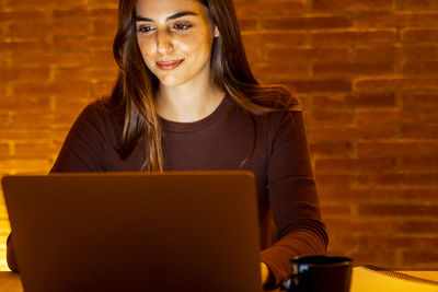 Young woman using laptop at home