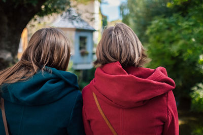 Rear view of sisters standing in city