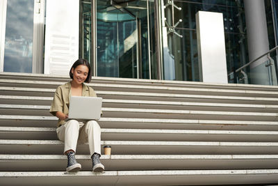 Portrait of young woman sitting on staircase