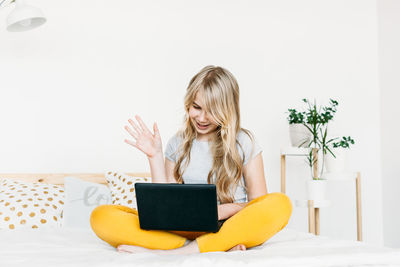 Young woman using mobile phone at home