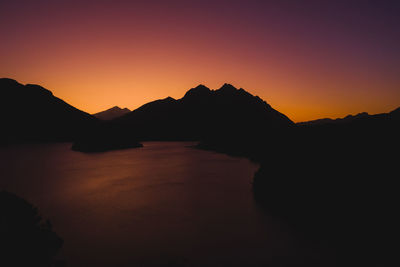 Scenic view of silhouette mountains against romantic sky at sunset
