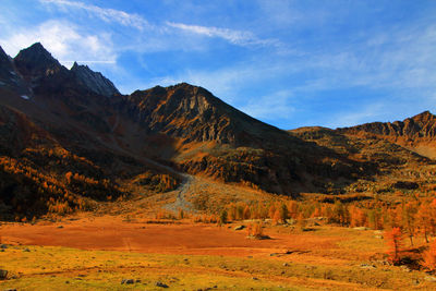 Scenic view of field and mountains against sky