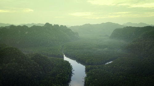 Scenic view of river by mountains against sky