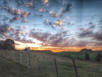 Barbed wire on field at sunset