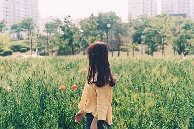 Rear view of woman standing on field