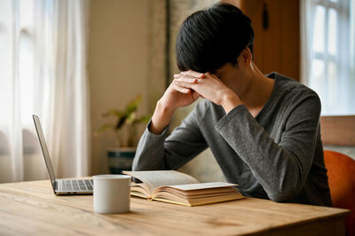 Side view of young businesswoman working at table