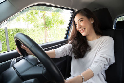 Portrait of smiling woman sitting in car