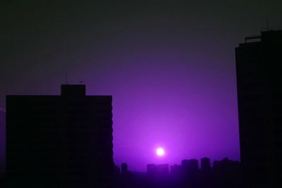 Illuminated cityscape against clear sky at night