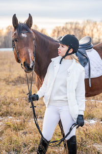 Rear view of man riding horse on field