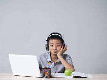 Young man using mobile phone while sitting on table