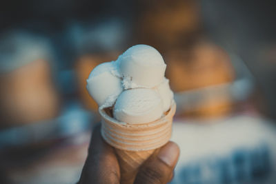 Close-up of hand holding ice cream cone outdoors