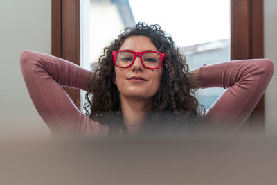 Portrait of young woman wearing sunglasses while sitting at home