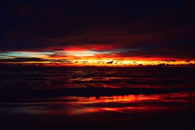 Scenic view of sea against dramatic sky during sunset