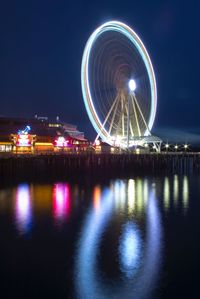 Illuminated ferris wheel at night