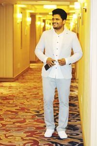 Full length of young man standing in hotel corridor