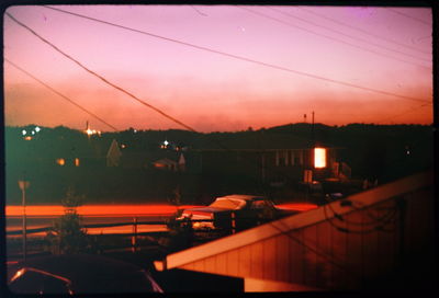 Electricity pylon against cloudy sky at dusk