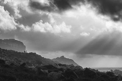 Scenic view of mountains against cloudy sky