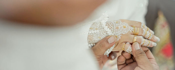 Groom holding brides hand during wedding ceremony