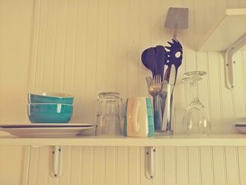 Close-up of jar on table against wall at home