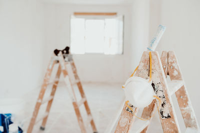 Ladders and painter tools on white room at construction site. painting walls. home improvement