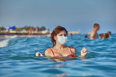 Portrait of woman wearing mask in sea