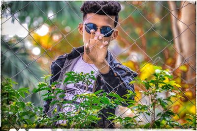 Portrait of young man photographing plants